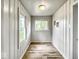 Hallway with beautiful wood-look vinyl flooring, windows with natural light, and vertical wainscotting at 4034 N Temple Ave, Indianapolis, IN 46205