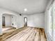 Freshly painted living room with new wood flooring and an arched doorway leading to the dining area at 4034 N Temple Ave, Indianapolis, IN 46205