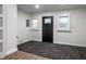 Basement space featuring carpeted floors, a black exterior door, and white trim at 4245 Norwaldo Ave, Indianapolis, IN 46205