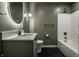 This bathroom features a bathtub, modern sink and vanity, and an oval lighted mirror at 4245 Norwaldo Ave, Indianapolis, IN 46205