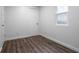 This bedroom features hardwood floors, white trim, one window, and a door at 4245 Norwaldo Ave, Indianapolis, IN 46205
