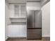 Kitchen features stainless steel fridge, white cabinets with glass, and modern countertops at 4245 Norwaldo Ave, Indianapolis, IN 46205