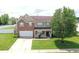 Two-story brick home features a well-manicured lawn and an attached two-car garage at 5063 Haywood Ln, Plainfield, IN 46168