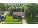Aerial view of a charming home boasting a well-manicured lawn, mature trees, and a welcoming front yard at 5201 Gringo Dr, Indianapolis, IN 46237