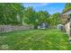 Spacious backyard featuring a well-maintained lawn, wooden fence, and mature trees, perfect for outdoor activities and relaxation at 5201 Gringo Dr, Indianapolis, IN 46237