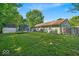 Wide shot of the home's expansive backyard with a trampoline, shed, and well-kept lawn providing ample outdoor space at 5201 Gringo Dr, Indianapolis, IN 46237