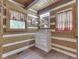 Bathroom with white cabinets, wood paneling and coordinating red and green curtains at 5240 W 400 N, Fairland, IN 46126