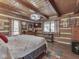 Cozy bedroom with wood-paneled walls, beamed ceiling, and a comfortable-looking bed with stylish bedding at 5240 W 400 N, Fairland, IN 46126