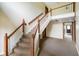 A carpeted hallway with wood banisters, white spindles, and view into a doorway at 526 W Hunters Dr # C, Carmel, IN 46032
