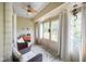 Cozy sunroom with large windows, wicker chairs, neutral rug, and a ceiling fan for relaxing at 526 W Hunters Dr # C, Carmel, IN 46032