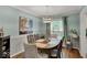 Bright dining room boasts hardwood floors, elegant furniture, and stylish light fixture at 5378 Rosslyn Ave, Indianapolis, IN 46220