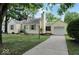 Quaint yellow home features a one-car garage, tidy landscaping, and a paved driveway at 5378 Rosslyn Ave, Indianapolis, IN 46220