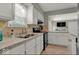 Well-lit kitchen featuring white cabinets, neutral countertops, and updated appliances at 5378 Rosslyn Ave, Indianapolis, IN 46220