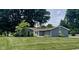 Charming single-story home with well-manicured lawn, mature trees and bright yellow front door at 540 Lazy Ln, Greenwood, IN 46142