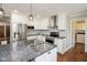 Well-lit kitchen featuring stainless appliances, range hood, granite counters and white cabinetry at 540 Lazy Ln, Greenwood, IN 46142