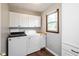 This laundry room features a washer and dryer, white cabinets, wood-look floors, and natural light at 540 Lazy Ln, Greenwood, IN 46142