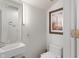 Modern half bathroom featuring a wall-mounted sink, toilet, and a decorative picture at 5424 Broadway St, Indianapolis, IN 46220