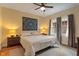 Cozy bedroom with hardwood floors, a ceiling fan, a neutral color scheme and natural light from the window at 5424 Broadway St, Indianapolis, IN 46220