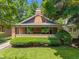 Charming brick home featuring a cozy front porch and well-manicured landscaping at 5424 Broadway St, Indianapolis, IN 46220
