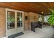 Inviting front porch with wooden ceiling, pew seating, and charming decor details at 5424 Broadway St, Indianapolis, IN 46220