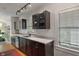 A well-lit kitchen featuring dark wood cabinetry, white countertops, stainless steel appliances and a sink under the window at 5424 Broadway St, Indianapolis, IN 46220