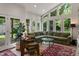 Spacious living room boasts large windows, an olive green sofa, terrazzo floor, and view of the backyard at 5424 Broadway St, Indianapolis, IN 46220