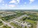 An aerial view of a Primary-planned community featuring homes with manicured lawns, lush trees, and a pond at 5723 Arctic Run Dr, Noblesville, IN 46062