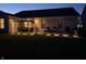 Evening view of the backyard patio featuring recessed outdoor lighting and lush green lawn at 5723 Arctic Run Dr, Noblesville, IN 46062
