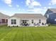 Backyard featuring a patio with outdoor seating, a manicured lawn, and tasteful landscaping at 5723 Arctic Run Dr, Noblesville, IN 46062