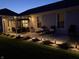 A relaxing backyard patio featuring outdoor seating and landscaping, illuminated by evening lights at 5723 Arctic Run Dr, Noblesville, IN 46062