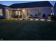 An evening view of the backyard patio, showcasing the outdoor lighting and landscaping at 5723 Arctic Run Dr, Noblesville, IN 46062