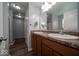 Bathroom featuring double sinks, wood cabinets, and a large mirror with modern lighting at 5859 Edelle Dr, Indianapolis, IN 46237