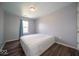 Bright bedroom featuring a window with curtains and hardwood-style flooring at 5859 Edelle Dr, Indianapolis, IN 46237