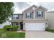 Charming two-story home featuring a brick and siding facade, complemented by a well-maintained front yard at 5859 Edelle Dr, Indianapolis, IN 46237