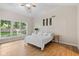 Bright bedroom features hardwood floors and a window offering a peaceful backyard view at 5997 Hollythorn Pl, Carmel, IN 46033