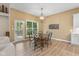Cozy dining room features hardwood floors, chandelier, and view of the backyard through a glass door at 5997 Hollythorn Pl, Carmel, IN 46033