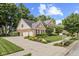 Expansive corner lot with a brick two-story home featuring a three car garage, a basketball hoop, and manicured landscaping at 5997 Hollythorn Pl, Carmel, IN 46033