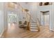 Elegant two story foyer with staircase, hardwood floors and decorative lighting at 5997 Hollythorn Pl, Carmel, IN 46033