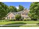 Beautiful two-story brick home with manicured lawn, mature trees, and classic architectural details at 5997 Hollythorn Pl, Carmel, IN 46033