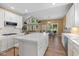 Updated eat-in kitchen features white cabinets, stainless steel appliances, an island, and hardwood floors at 5997 Hollythorn Pl, Carmel, IN 46033