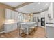 Charming eat-in kitchen features white cabinets, hardwood floors, stainless steel appliances, and an island at 5997 Hollythorn Pl, Carmel, IN 46033