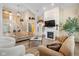 Open living room includes a fireplace, built-in shelving, hardwood floors, and stairs to the second floor at 5997 Hollythorn Pl, Carmel, IN 46033
