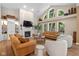 Bright living room features a fireplace, built-in shelving, hardwood floors, and large windows overlooking trees at 5997 Hollythorn Pl, Carmel, IN 46033