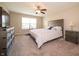 This bedroom features neutral walls and carpeting and also includes a fan and a large window for lots of natural light at 610 Sawtooth St, Westfield, IN 46074