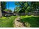 Lush backyard with stepping stone path, mature trees, and well-maintained lawn at 6146 Burlington Ave, Indianapolis, IN 46220
