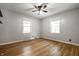 Bright bedroom with hardwood floors, neutral walls, ceiling fan, and natural light from two windows at 6146 Burlington Ave, Indianapolis, IN 46220