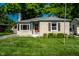 Charming stone home with a well-maintained lawn and a bright red front door at 6146 Burlington Ave, Indianapolis, IN 46220
