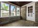 Cozy sunroom with stone walls, tile floor, and large windows offering natural light and backyard views at 6146 Burlington Ave, Indianapolis, IN 46220