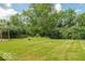Backyard featuring a well-maintained lawn and a variety of trees providing privacy and shade at 626 Tulip Poplar Ct, Mooresville, IN 46158