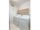 Well-lit laundry area with linoleum flooring, floating shelves, and modern washer and dryer at 626 Tulip Poplar Ct, Mooresville, IN 46158
